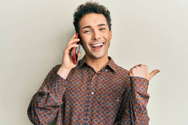 Mladý Pohledný Muž Rozhovorem Mluví Smartphone Ukazuje Palcem Nahoru Stranu — Stock fotografie