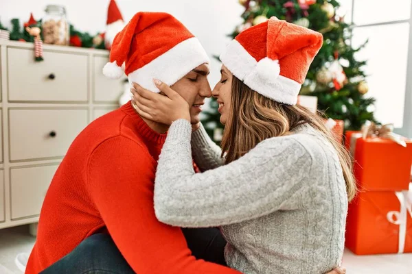 Young Couple Wearing Christmas Hat Kissing Sitting Floor Hugging Home — Stock Photo, Image