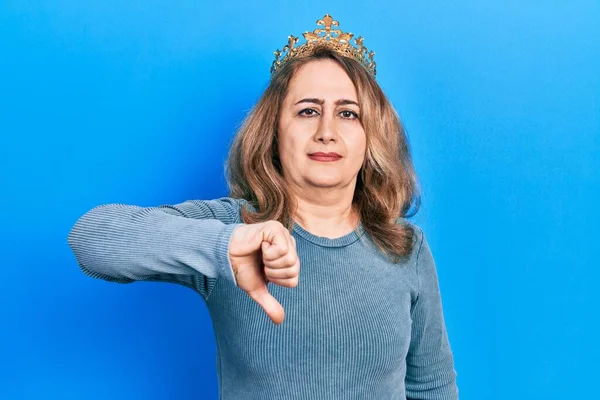 中世の白人女性は 女王の冠を身に着けていると不満と怒りを示し拒絶と親指ダウンジェスチャーで陰性に見えます 悪い表現 — ストック写真
