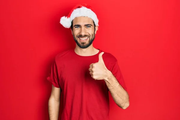 Νεαρός Ισπανός Που Φοράει Χριστουγεννιάτικο Καπέλο Κάνει Χαρούμενη Χειρονομία Χέρι — Φωτογραφία Αρχείου
