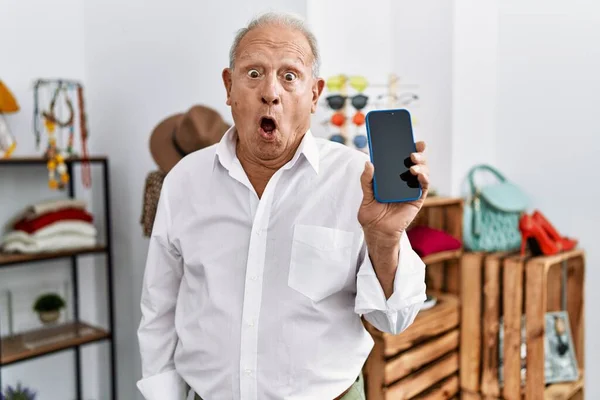 Senior Man Holding Smartphone Retail Shop Scared Amazed Open Mouth — Stock fotografie