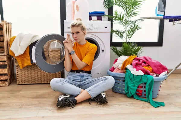 Jonge Blonde Vrouw Doet Zitten Bij Wasmachine Met Symbolisch Pistool — Stockfoto