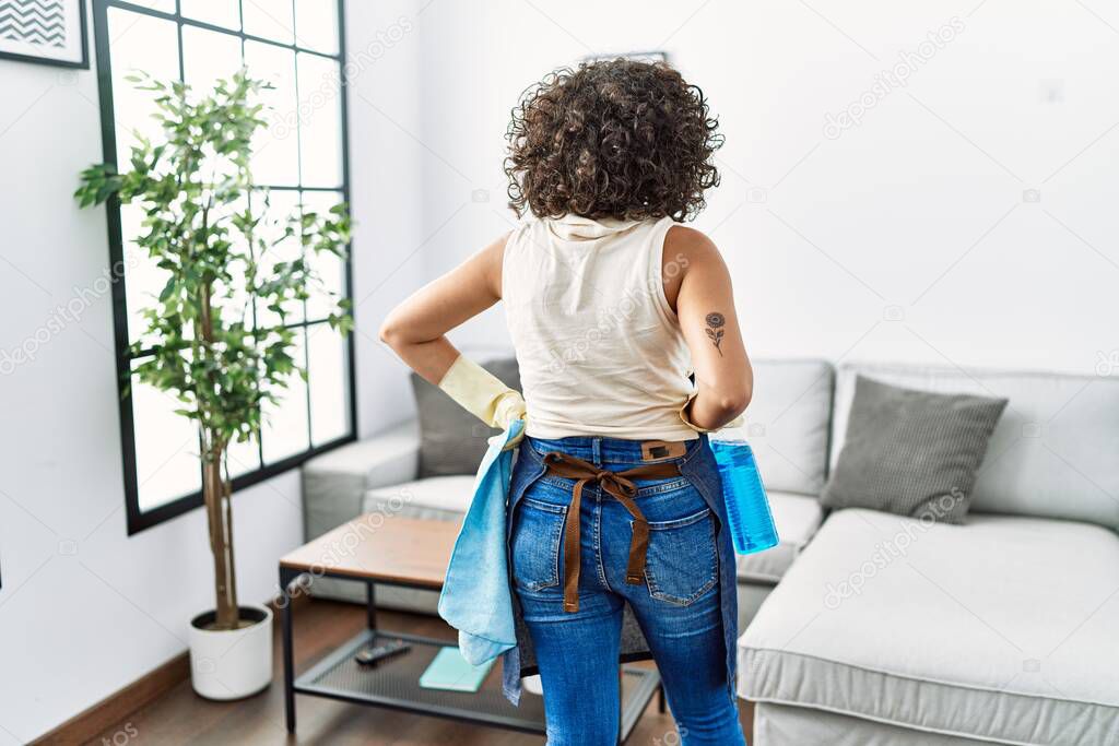 Young middle east woman holding cleaning cloth and spayer at home