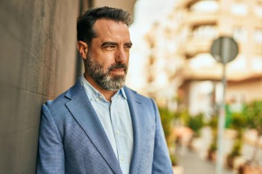 Şehirde duran rahat yüzlü orta yaşlı iş adamı..