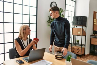 Ofiste çalışırken ve kahve içerken gülümseyen iki iş adamı..