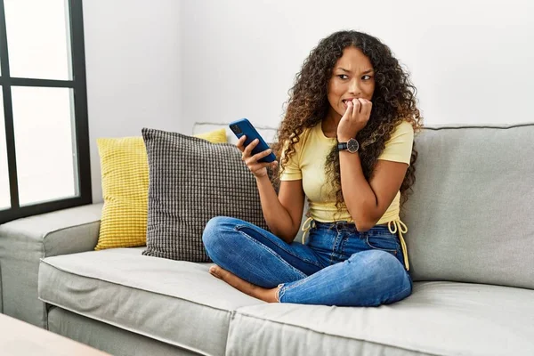 Hermosa Mujer Hispana Sentada Sofá Casa Usando Teléfono Inteligente Que —  Fotos de Stock