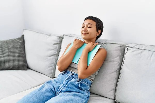 Jonge Latino Vrouw Glimlachen Zelfverzekerd Knuffelen Boek Thuis — Stockfoto