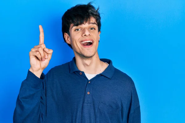 Przystojny Hipsterski Młody Człowiek Tkwiący Niebieskim Tle Wskazujący Palcem Udany — Zdjęcie stockowe