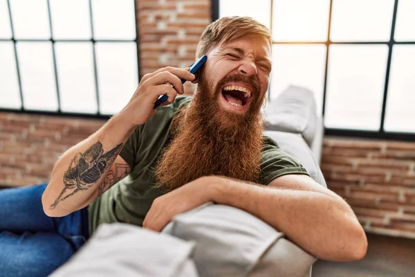 Giovane Rossa Uomo Sorridente Fiducioso Parlando Sullo Smartphone Casa — Foto Stock