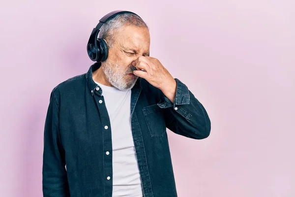 Hombre Mayor Guapo Con Barba Escuchando Música Usando Auriculares Oliendo — Foto de Stock