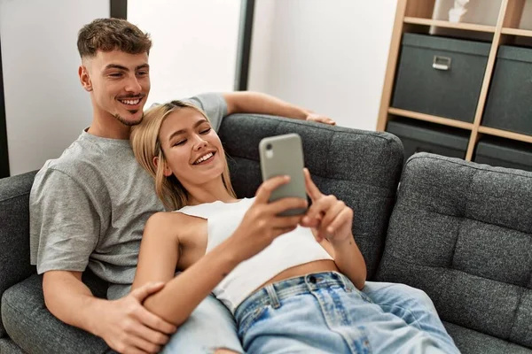 Молода Біла Пара Посміхається Щасливий Використовуючи Смартфон Вдома — стокове фото