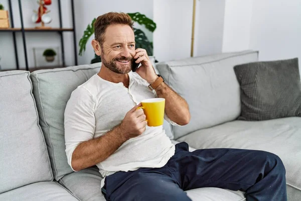 Hombre Hispano Mediana Edad Hablando Teléfono Inteligente Bebiendo Café Casa — Foto de Stock