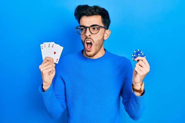 Молодой Латиноамериканец Играет Покер Держа Руках Фишки Карты Казино Злой — стоковое фото