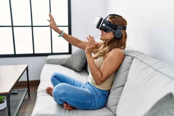 若いですラテン女性遊びビデオゲームを使用して仮想現実の眼鏡で自宅 — ストック写真