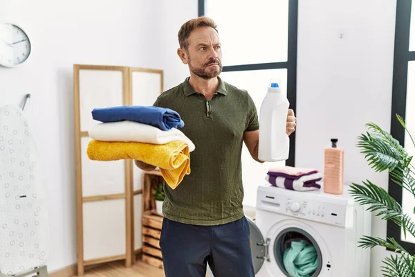 Hombre Mediana Edad Sosteniendo Ropa Limpia Botella Detergente Sonriendo Mirando — Foto de Stock