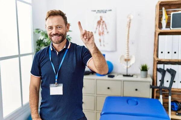 Middle Age Physiotherapist Man Working Pain Recovery Clinic Showing Pointing — Stockfoto