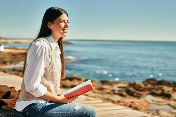 Joven Mujer Hispana Sonriendo Feliz Libro Lectura Playa —  Fotos de Stock