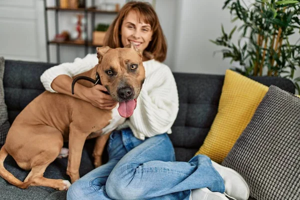 Junge Kaukasierin Lächelt Selbstbewusst Und Umarmt Hund Der Hause Auf — Stockfoto