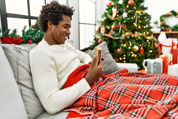 Joven Afroamericano Hombre Sosteniendo Foto Sentado Sofá Por Árbol Navidad — Foto de Stock