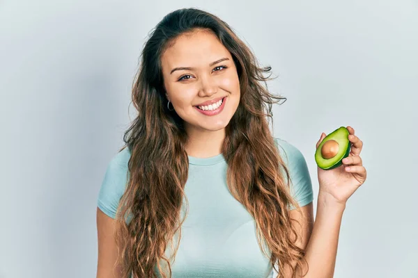 Menina Hispânica Jovem Segurando Meio Abacate Olhando Positivo Feliz Sorrindo — Fotografia de Stock