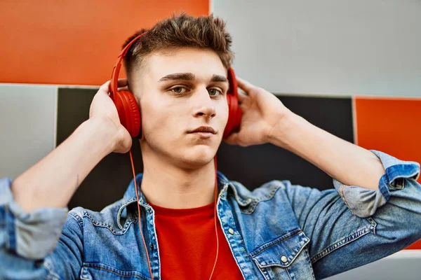 Joven Chico Caucásico Con Auriculares Escuchando Música Apoyada Pared —  Fotos de Stock