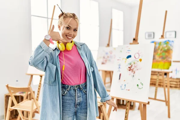 Young Caucasian Girl Art Studio Smiling Doing Phone Gesture Hand — Zdjęcie stockowe