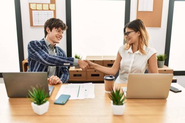 İki iş adamı gülümseyerek ofiste el sıkışırken mutlu olur..