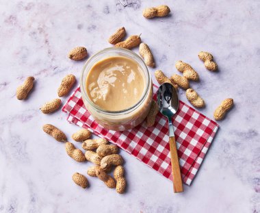  Fıstık ezmesi ve fıstık ezmesi kremalı mermer bir yüzey.