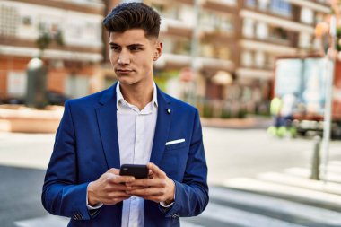 Sokakta akıllı telefon kullanan genç bir adam.