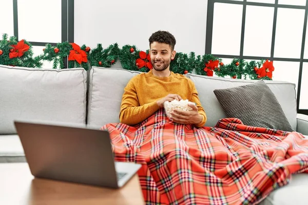 Jovem Árabe Homem Assistindo Filme Sentado Sofá Por Decoração Natal — Fotografia de Stock