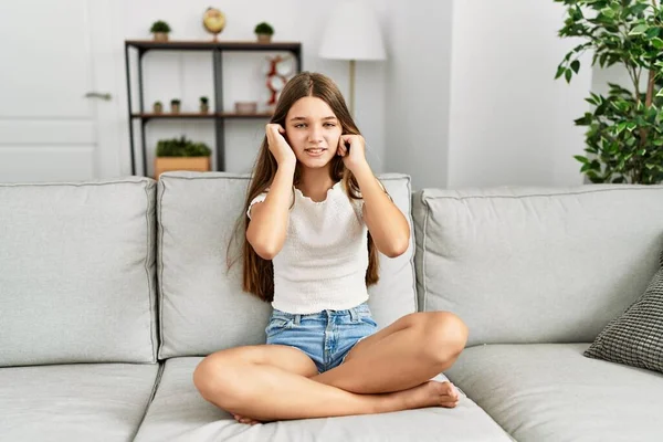 Mladý Bruneta Teenager Sedí Doma Pohovce Zakrývá Uši Prsty Otráveným — Stock fotografie