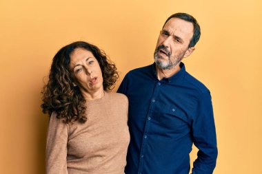 Orta yaşlı İspanyol çift rahat kıyafetler giyiyor. Uykulu ve yorgun görünüyorlar. Yorgunluktan bitkin düşmüş, akşamdan kalma, tembel gözlü.. 