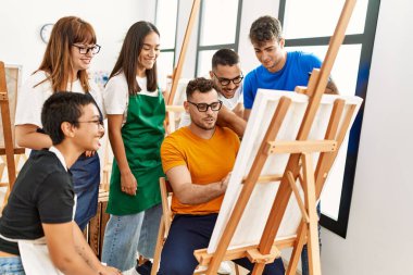 Mutlu gülümseyen ve ortak arayan bir grup insan sanat stüdyosunda..