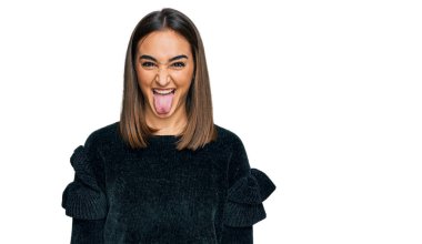 Zarif süveter giyen güzel esmer kadın komik bir ifadeyle dilini dışarı çıkartıyor. duygu kavramı. 