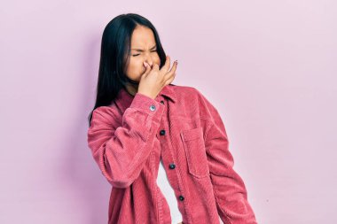 Güzel İspanyol bir kadın, burun piercingli, sıradan pembe bir ceket giyiyor, pis ve iğrenç bir koku alıyor, dayanılmaz bir koku, nefesini burnunda tutuyor. Kötü kokuyor. 