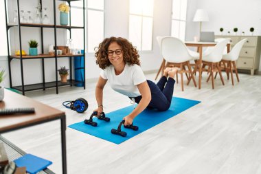 Evde yoga egzersizi yapan genç bir kadın.