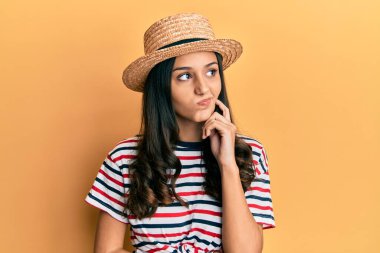 Yazlık şapkalı, ciddi yüzlü, eli çenesinde soru soran genç İspanyol kadın kafa karıştırıcı bir fikir hakkında düşünceli. 