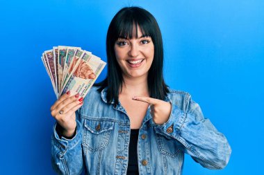 Genç İspanyol kadın elinde Mısır banknotları tutarken mutlu mesut gülümsüyor. 