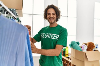 Yardım merkezinde çalışırken gülümseyen Latin asıllı gönüllü adam..