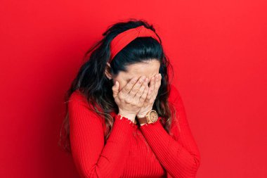 Ağlarken yüzünü ellerle kapatan, günlük kıyafetler giyen genç İspanyol kadın. depresyon kavramı. 