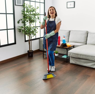 Orta yaşlı İspanyol kadın evde hizmetçi olarak dans ediyor.