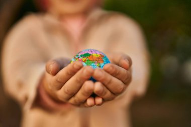 Küçük bir dünya topunu elinde tutan İspanyol kadının elleri şehirde duruyor..