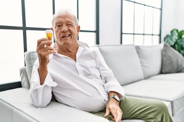 Uomo Anziano Che Tiene Pillole Ammiccando Guardando Fotocamera Con Espressione — Foto Stock