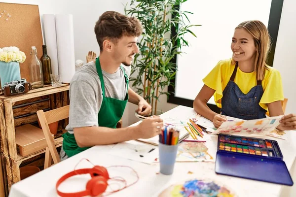 年轻的他的惊慌失措的艺术家夫妇在艺术工作室开心地微笑着画画 — 图库照片