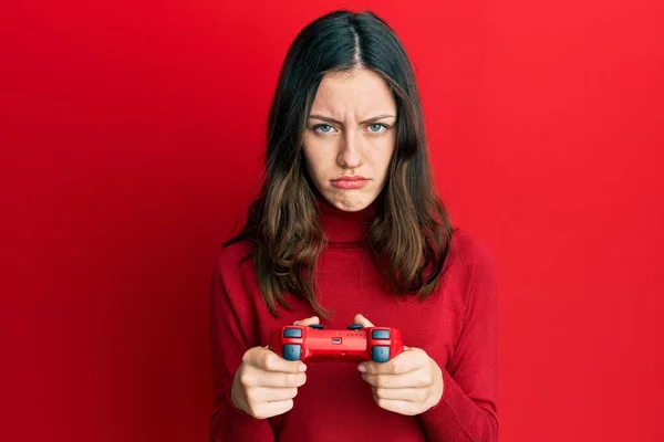Νεαρή Μελαχρινή Γυναίκα Παίζει Video Game Κρατώντας Ελεγκτή Δύσπιστος Και — Φωτογραφία Αρχείου