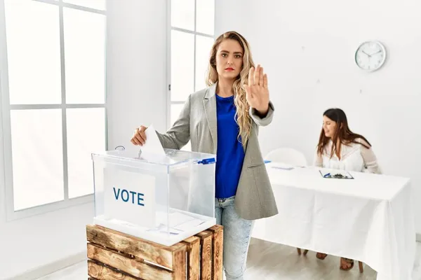 Mujer Rubia Joven Votando Poniendo Sobre Las Urnas Con Mano —  Fotos de Stock