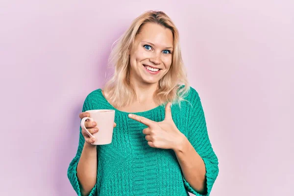 Piękne Biały Blondynka Kobieta Pije Filiżanka Kawa Uśmiechając Szczęśliwy Wskazując — Zdjęcie stockowe