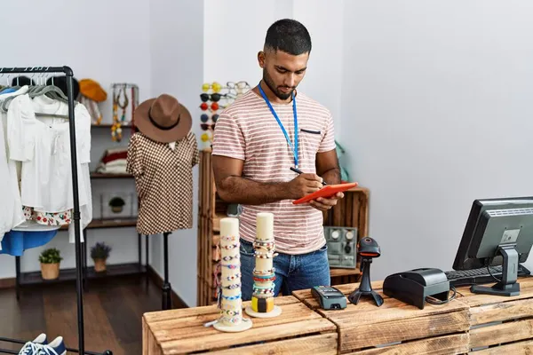 在服装店工作的年轻阿拉伯男子使用触摸板 — 图库照片