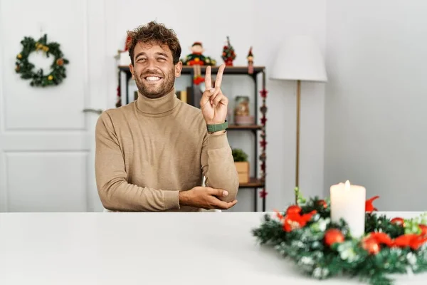 Young Handsome Man Beard Sitting Table Christmas Decoration Smiling Happy — стоковое фото