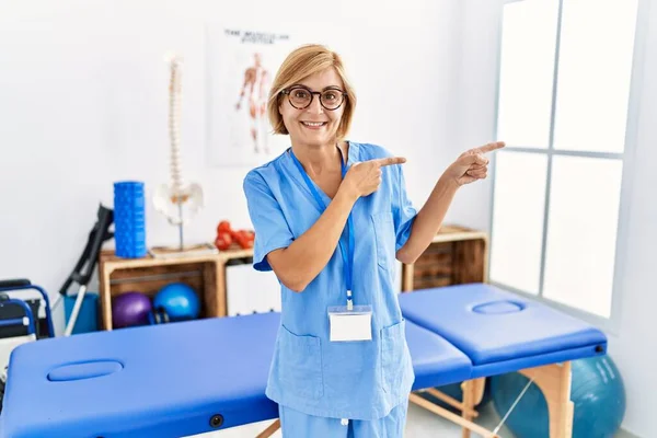 Mulher Loira Meia Idade Trabalhando Clínica Recuperação Dor Sorrindo Olhando — Fotografia de Stock